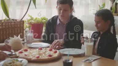 男孩和女孩在咖啡厅慢动作视频中吃披萨。 <strong>孩子</strong>们吃比萨饼，吃美味的比萨饼。 朋友的<strong>陪</strong>伴